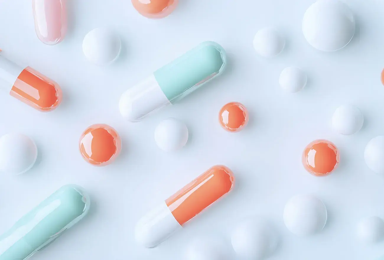 Colorful capsules and round pills on a white background