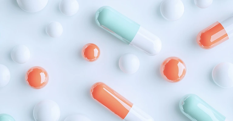 Colorful capsules and round pills on a white background