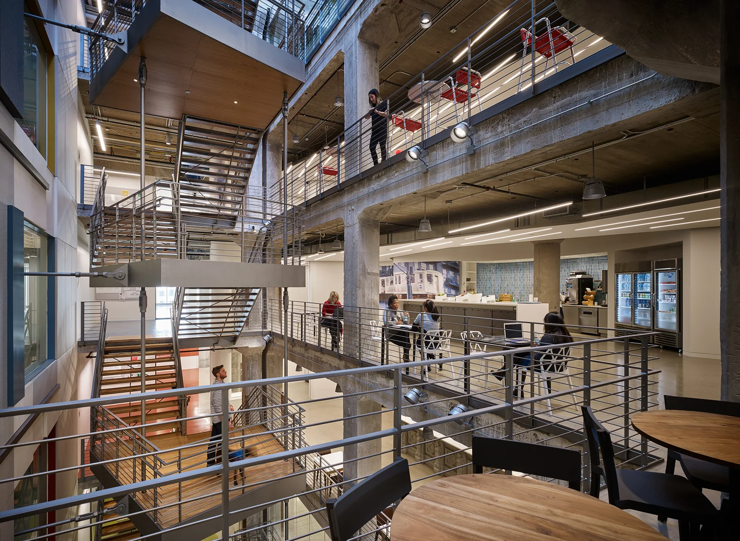 Modern multi-level interior of Google Chicago office with open seating, industrial design, and people working.