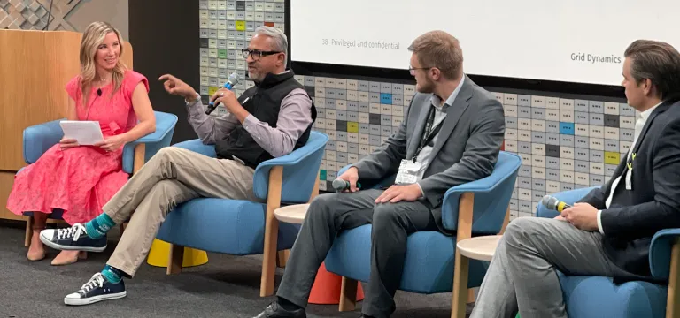 Panel discussion at AI-enabled experiences event with four speakers seated on stage, engaging in conversation.